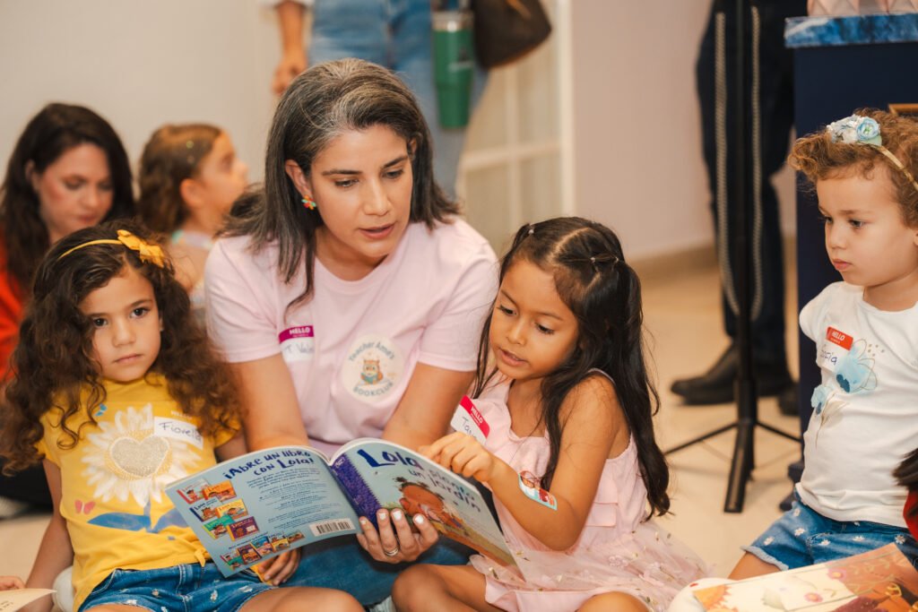 Lectura en voz alta con un grupo de niñas y niños sentados en el suelo